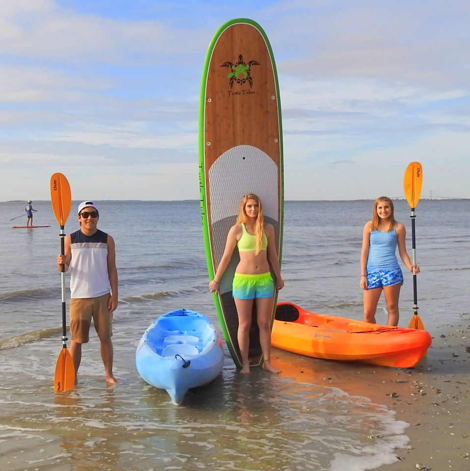 Kids displaying their Turtle Tides paddle boards and kayaks. 